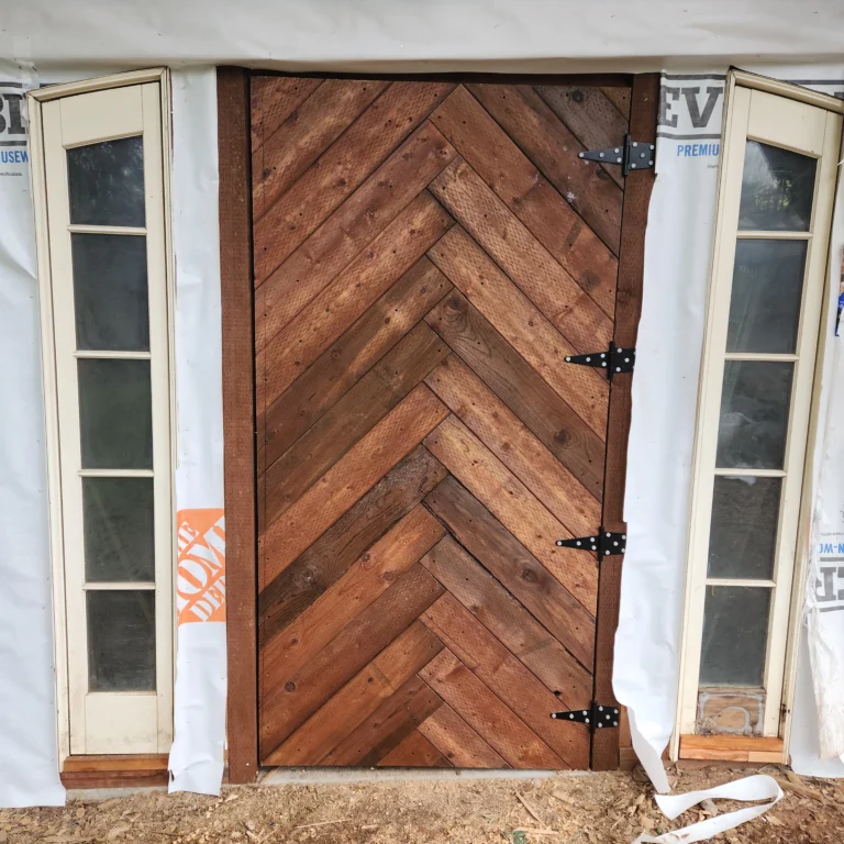 large wooden door with boards in a chevron pattern