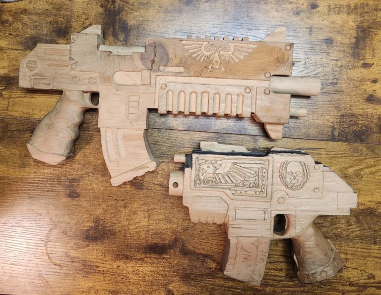 handcarved Warhammer 40k bolter above handcarved Warhammer 40k bolter pistol