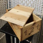 side view of wooden box with lid ajar